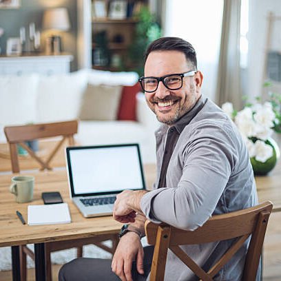 Homme assis à son bureau à la maison avec ordinateur.